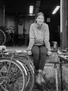 Jenny sitting surrounded by bikes